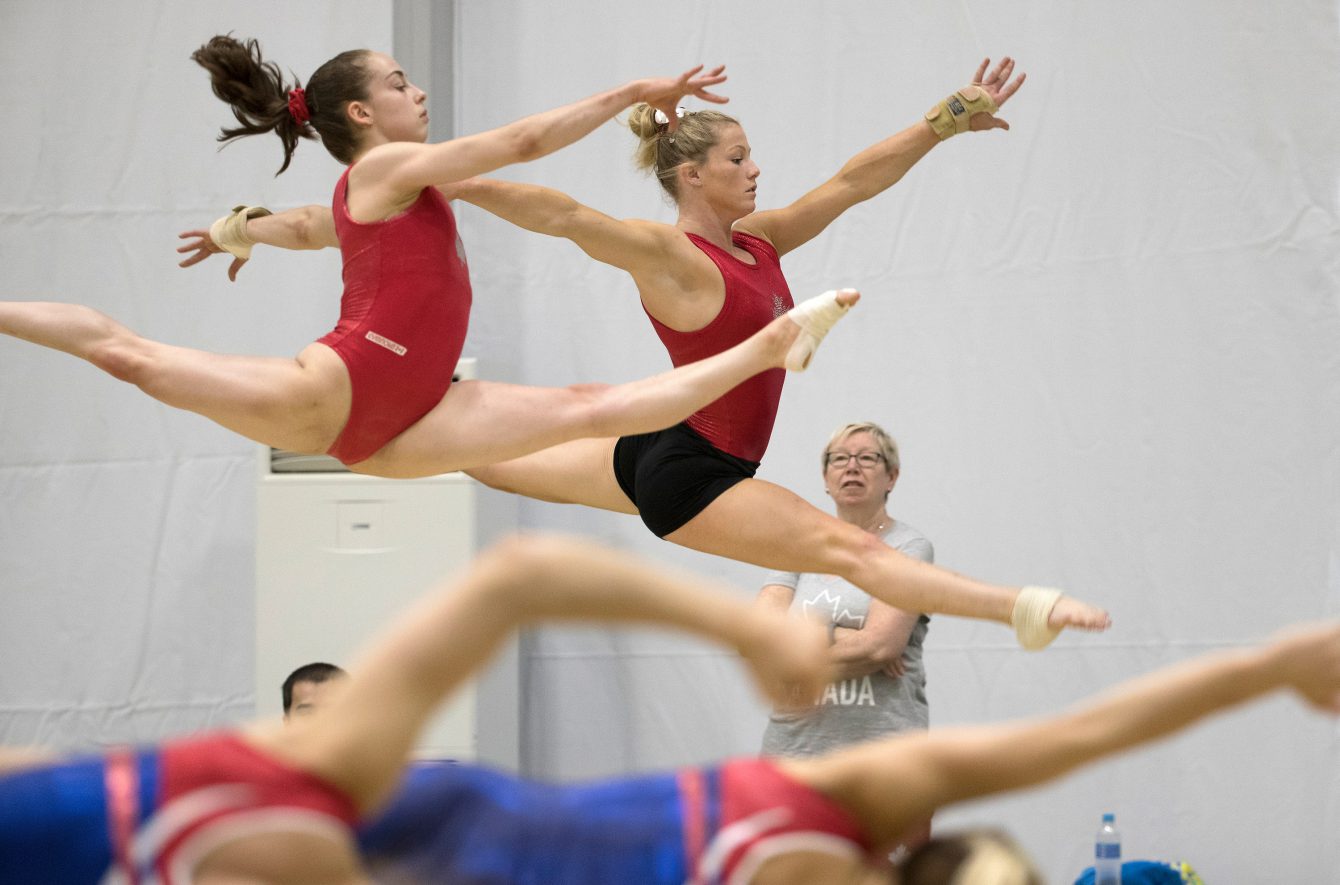 Girls Training Gymnastics At School Gym by Stocksy Contributor