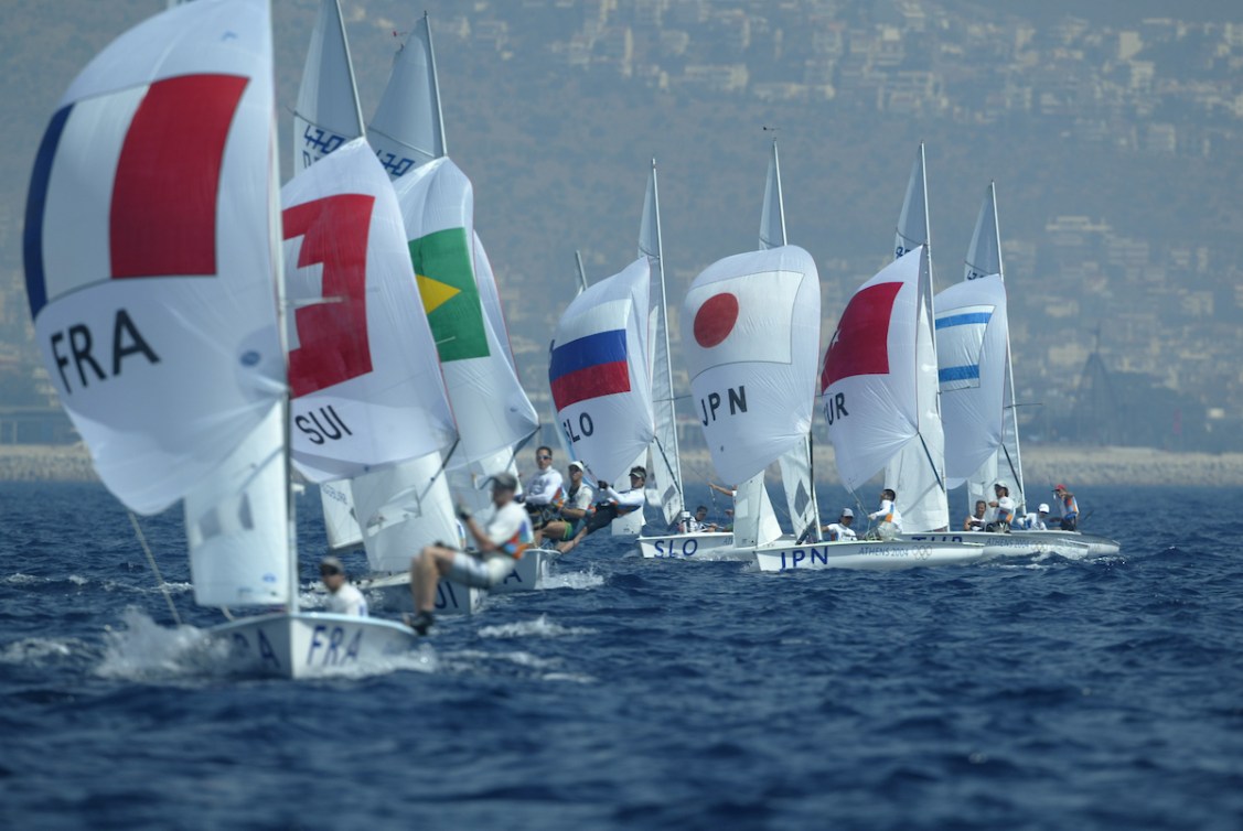 A lot of sailing boats in a line as they race on the ocean 