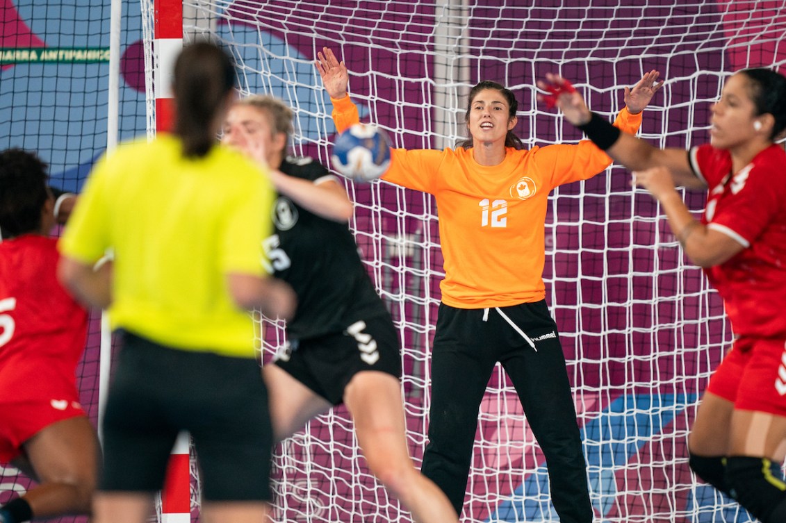 Handball goalkeeper holds her arms up to prepare to stop a ball 