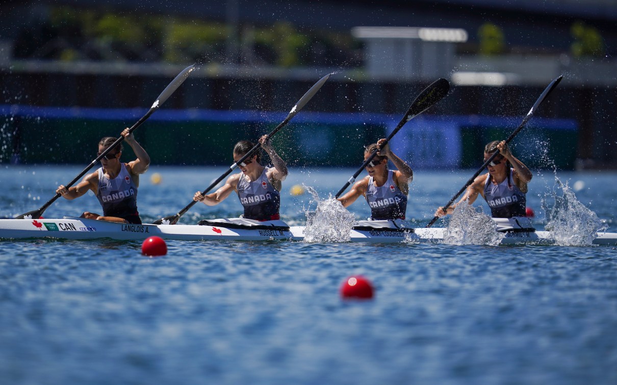 Four Canadian women paddle their kayak in a race 