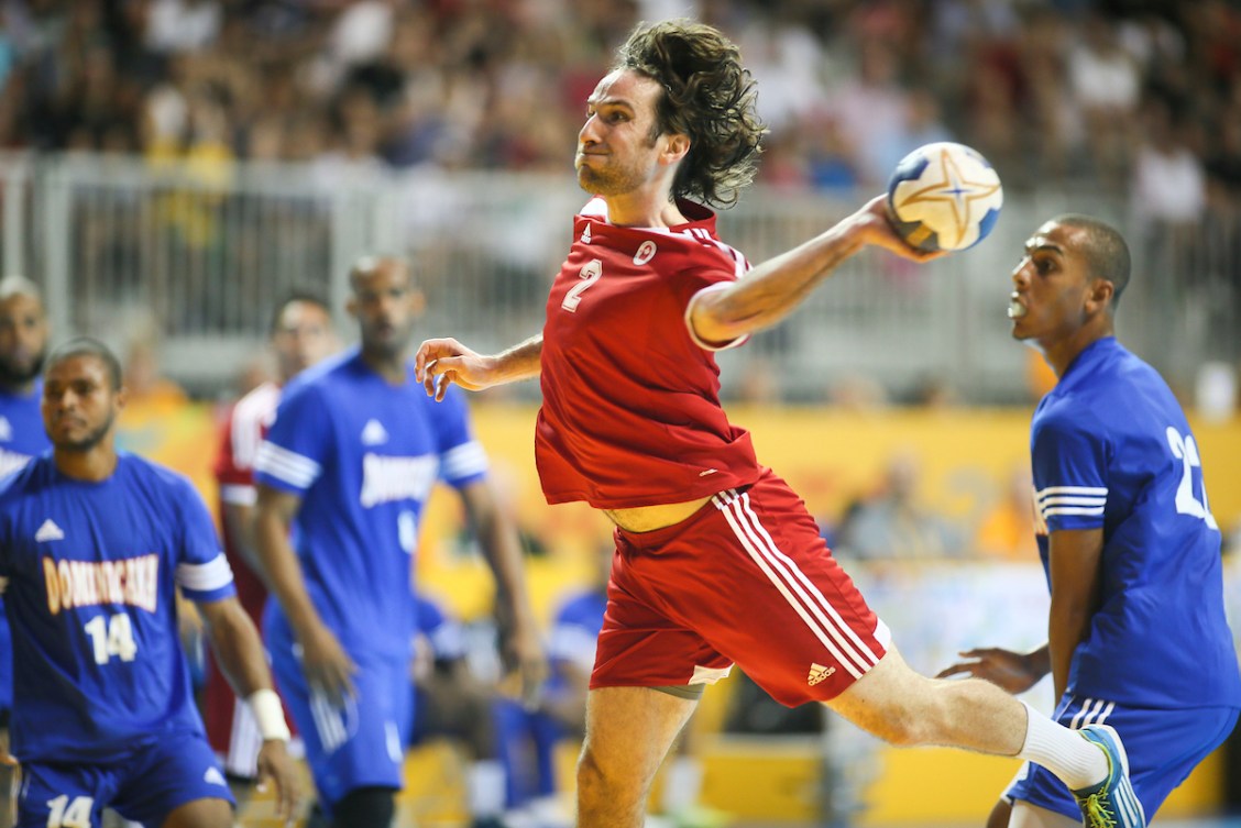 Canadian handball player dressed in red prepares to throw the ball 