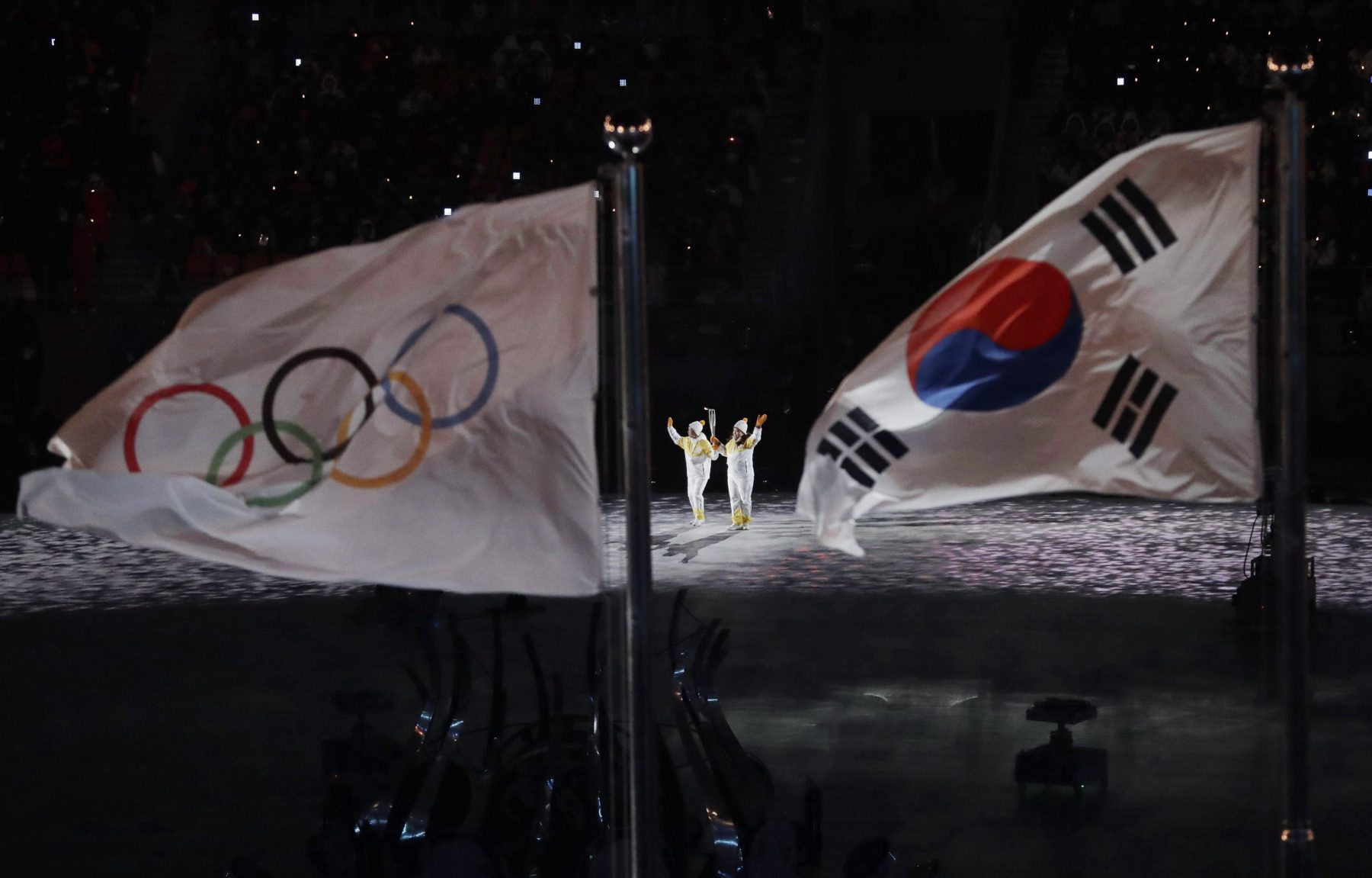 The Olympic torch is carried into the stadium during the opening ceremony of the 2018 Olympic Winter Games