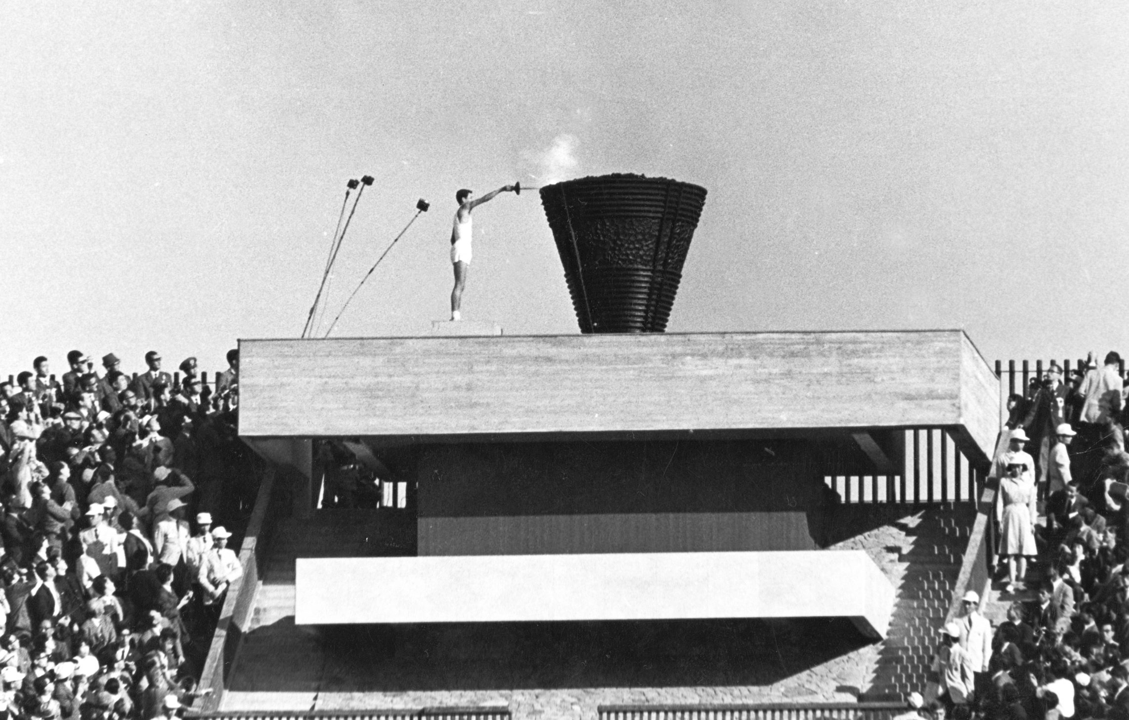 Japanese runner Yoshinori Sakai lights the Olympic cauldron during the opening ceremony of the 1964 Olympic games in Tokyo