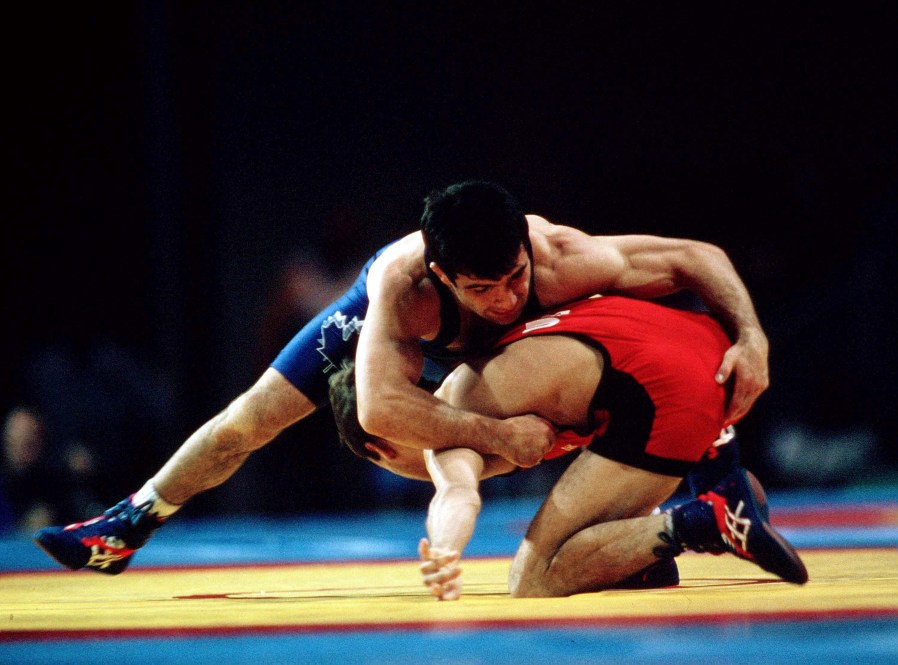Canada's Guivi Sissaouri (blue) competes in the wrestling event at the 1996 Atlanta Olympic Games. (CP Photo/COC/Mike Ridewood)