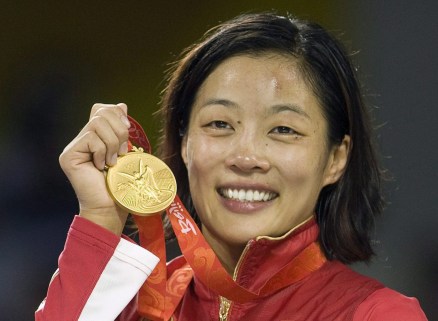 Canada's Carol Huynh from Hazelton, B.C. holds up her gold medal for the women's freestyle 48kg wrestling during victory ceremonies at the Beijing 2008 Summer Olympics in Beijing, Saturday, August 16, 2008.