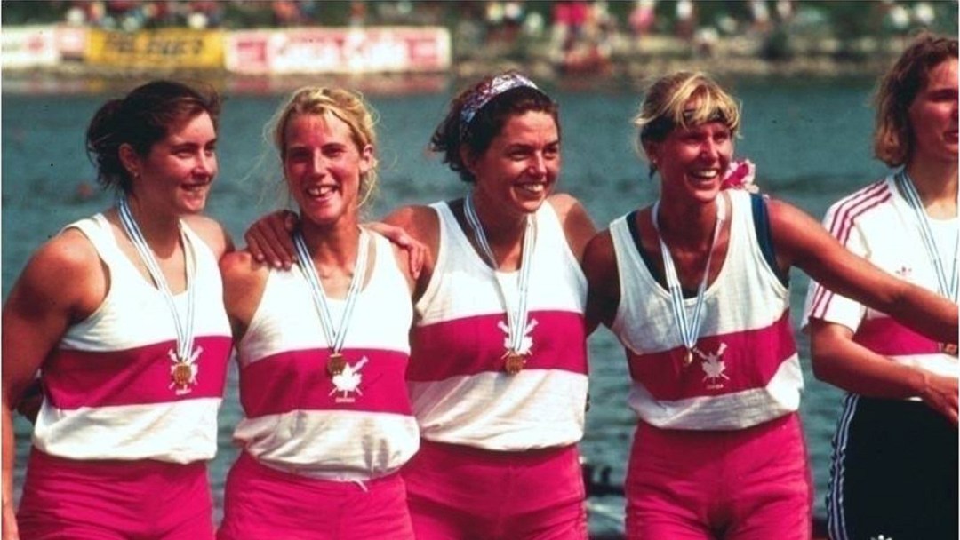 Four female rowers in Canadian uniforms wear gold medals