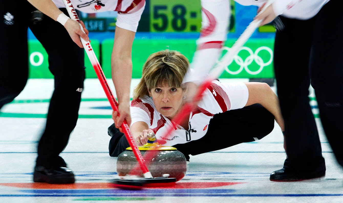 Carolyn Darbyshir pushes the rock with sweepers in front of her.