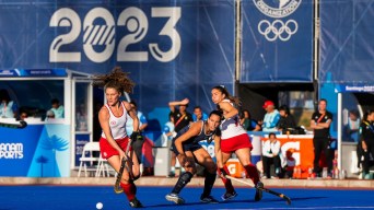 A group of field hockey player fights for the ball