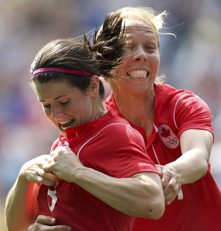 Diana Matheson points to the Olympic logo on her jersey