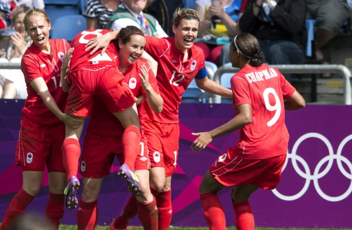 Canada forward Christine Sinclair (12), defender Rhian Wilkinson (7) and midfielder Brittany Timko (left) and defender Candace Chapman (9) hoist midfileder Diana Matheson into the air after she scored the game winning goal against France in second half Bronze medal football action at the Olympic Games in Coventry, Great Britain on Thursday August 9, 2012. THE CANADIAN PRESS/Frank Gunn