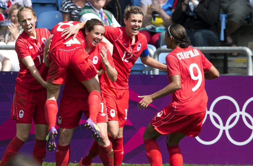 Canada forward Christine Sinclair (12), defender Rhian Wilkinson (7) and midfielder Brittany Timko (left) and defender Candace Chapman (9) hoist midfileder Diana Matheson into the air after she scored the game winning goal against France in second half Bronze medal football action at the Olympic Games in Coventry, Great Britain on Thursday August 9, 2012. THE CANADIAN PRESS/Frank Gunn