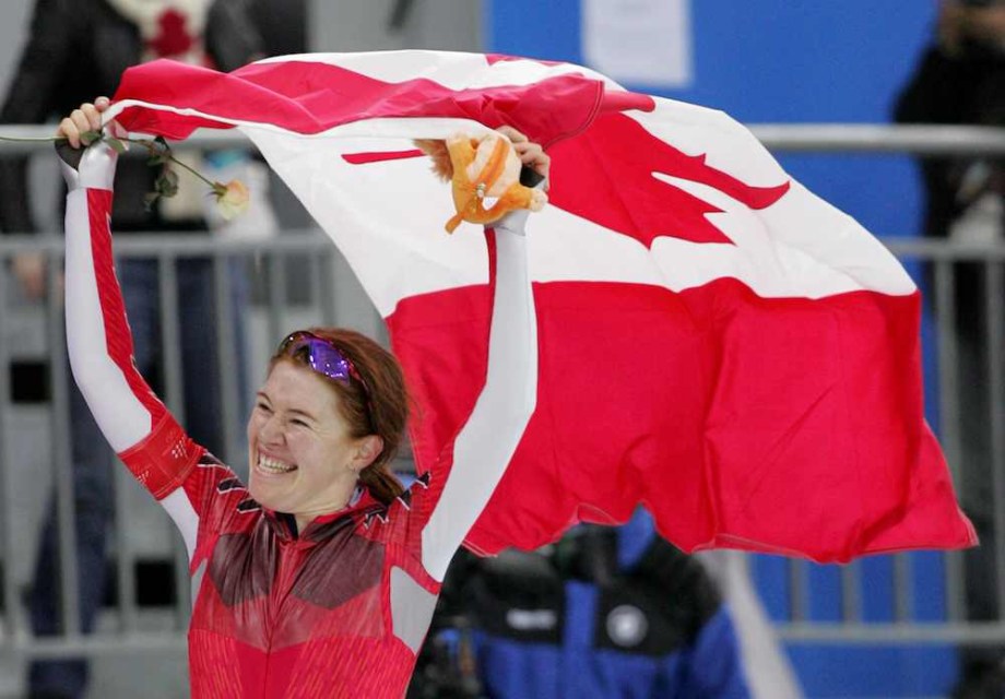 Hughes holding Canadian flag and smiling