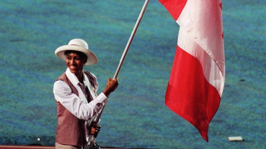 Opening Charmaine Crooks bears the Canadian flag at the Atlanta 1996 Olympic Games Opening Ceremony. (CP Photo/COC)