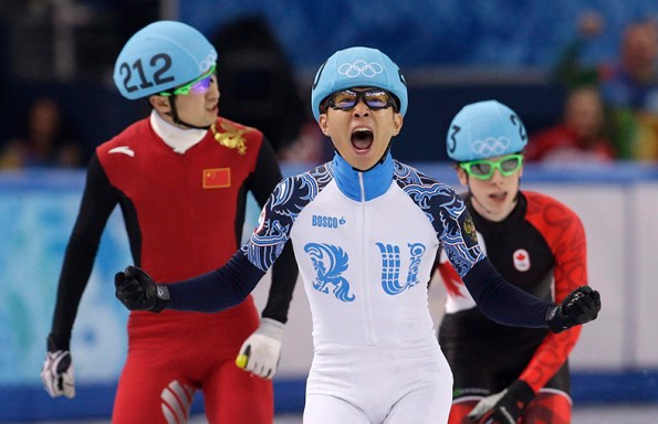 Victor An of Russia, centre, reacts as he crosses the finish line ahead of Wu Dajing of China, left, and Charle Cournoyer of Canada