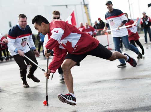 Speed skater Gilmore Junio takes a shot in a friendly ball hockey between Canada and the USA on February 19, 2014 at the 2014 Olympic Winter Games.