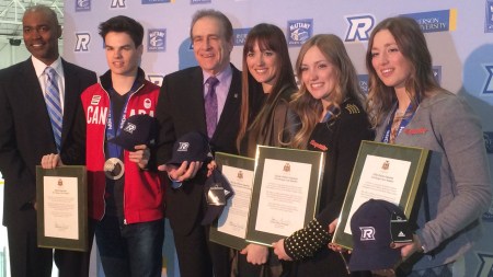 Toronto deputy mayor Norm Kelly (third from left) presents the Olympians with a scroll.