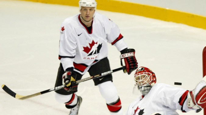 Rob Blake looks on as Martin Brodeur makes a save at Salt City 2002 men's ice hockey gold medal final. Canada beat the United States 5-2 to win the tournament.