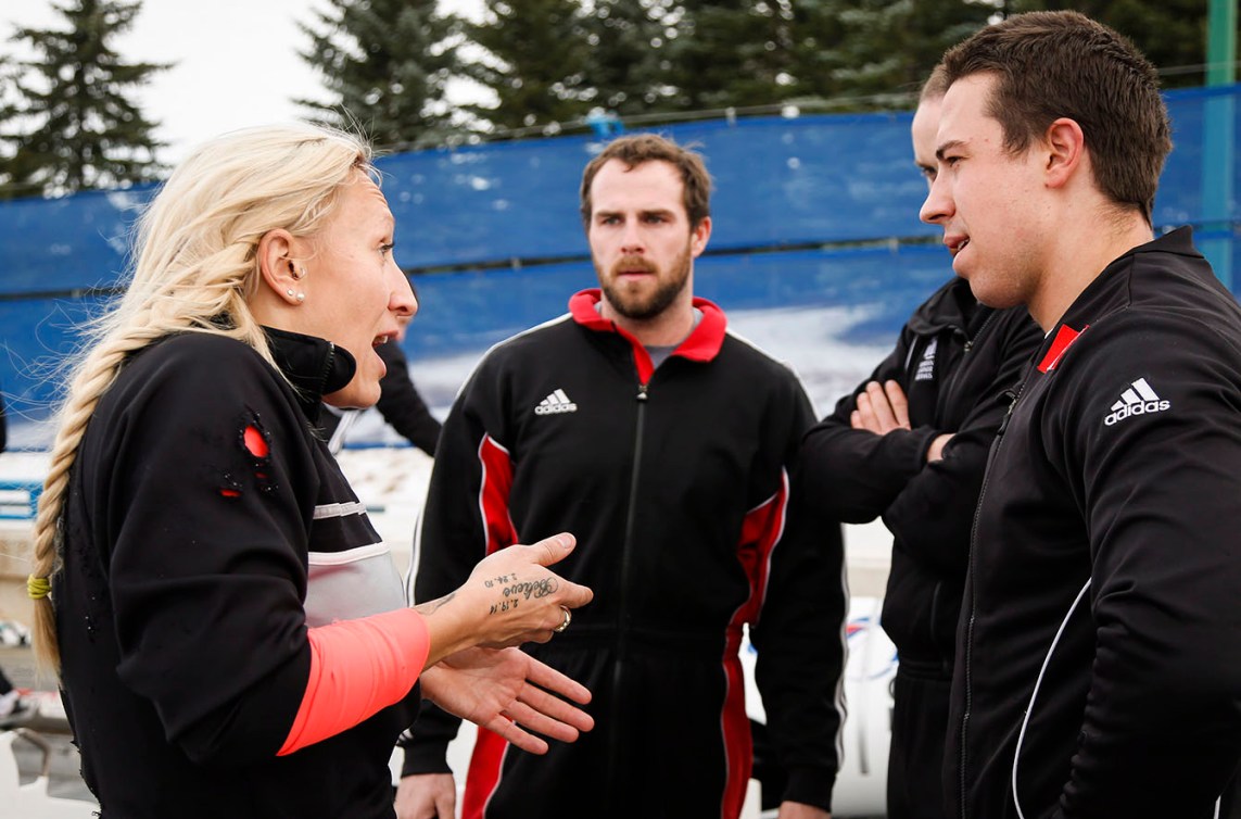 Bobsled pilot Kaillie Humphries, left, gestures as she talks with her male teammates following a training run at Canada Olympic Park in Calgary, Thursday, Nov. 20, 2014. THE CANADIAN PRESS/Jeff McIntosh