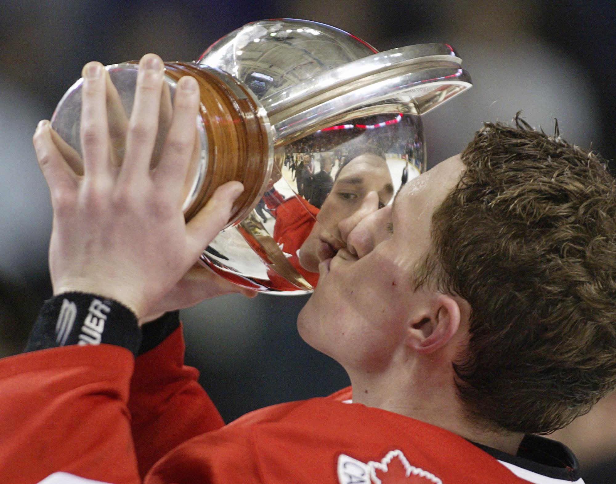 Un joueur de hockey embrasse un trophée.