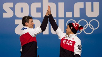 Denny Morrison (left) and Gilmore Junio high-five at Sochi's Main Press Centre.