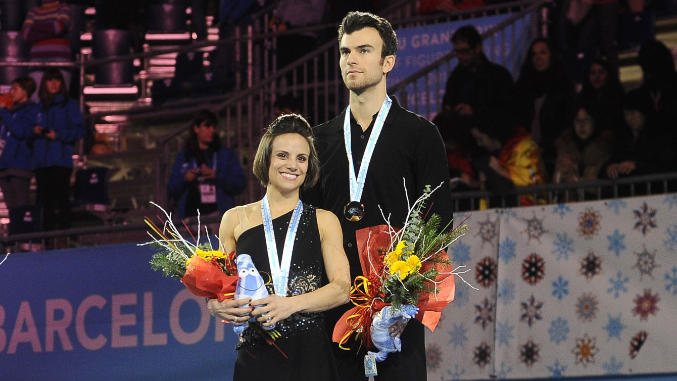 Meagan Duhamel and Eric Radford stand atop the pairs podium at the 2014 Grand Prix Final in Barcelona, Spain.