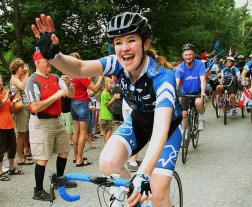 Clara Hughes waving on bike
