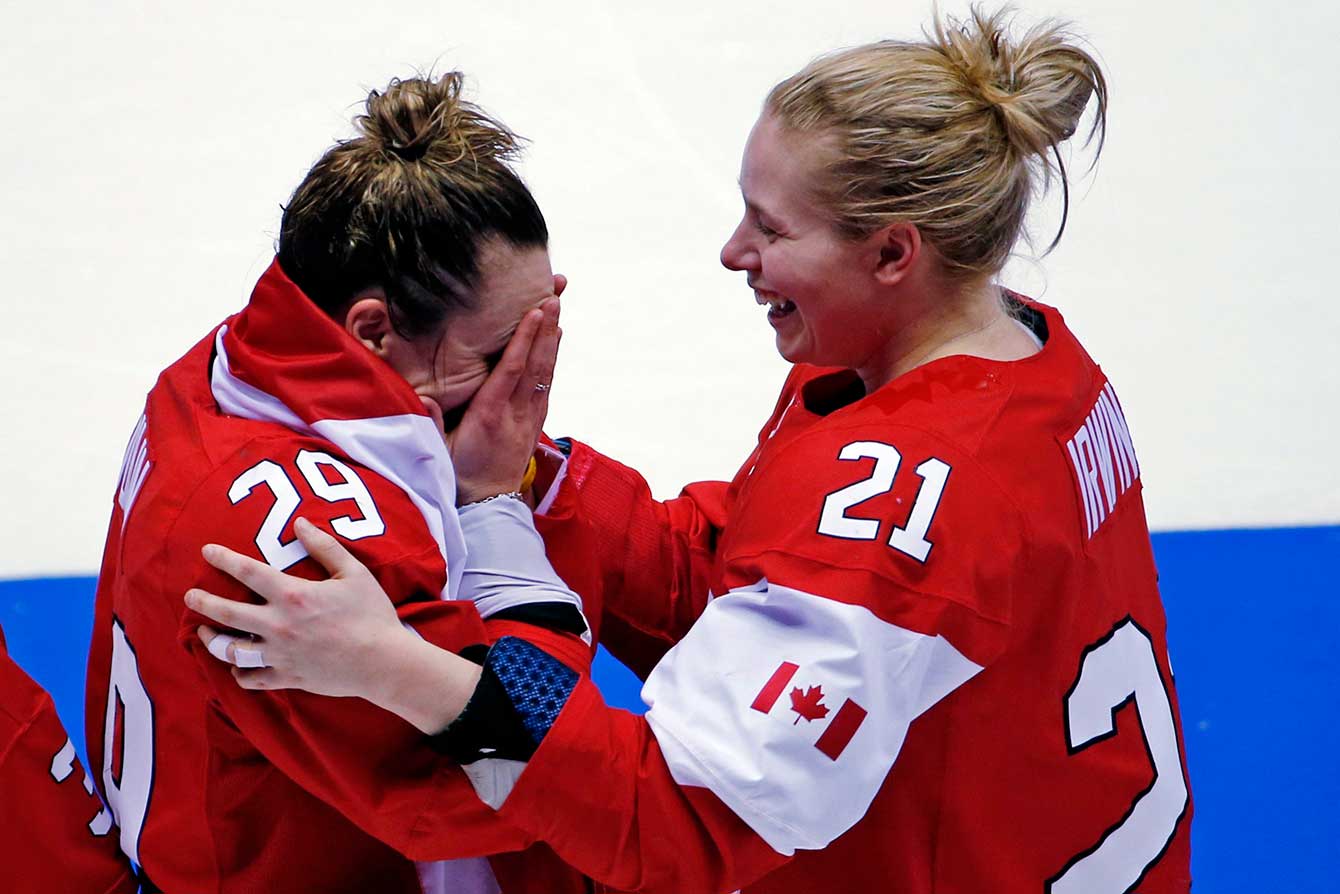 Marie-Philip Poulin of Canada (29) and Haley Irwin of Canada (21) celebrate their 3-2 overtime victory against the United States in the women's gold medal ice hockey game at the 2014 Winter Olympics, Thursday, Feb. 20, 2014, in Sochi, Russia. (AP Photo/Julio Cortez)