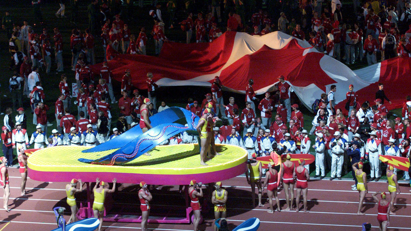 Canadian athletes begin to unfurl the giant flag at Sydney 2000 Closing Ceremony. The 18m x 9m flag rivals several Ceremony floats. 