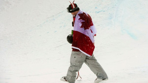Riddle heads back to the stands draped in Canada's flag after the flower ceremony at Rosa Khutor Extreme Park.