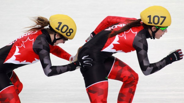 Marianne St-Gelais pushes Valérie Maltais as they tag up during the 3000m relay final at Sochi 2014.
