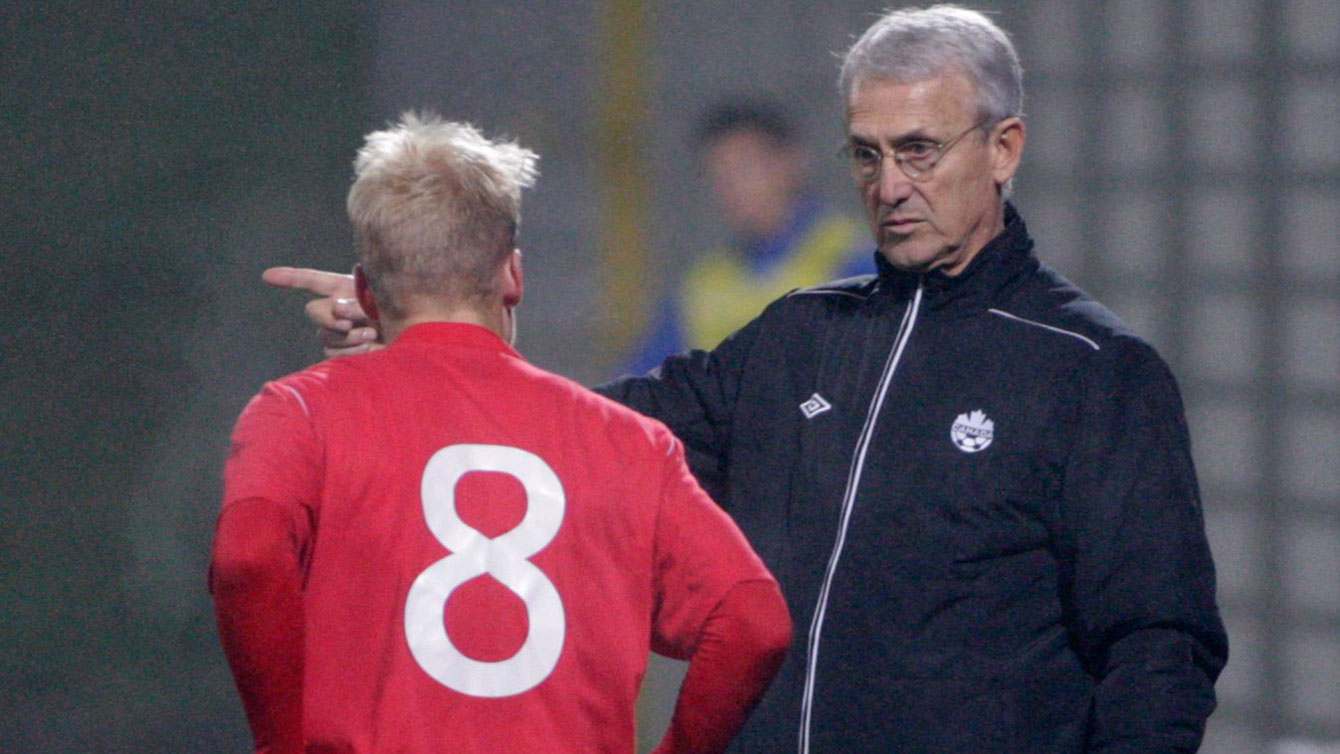 Canadian men's head coach Benito Floro instructs midfielder Kyle Bekker during a match. 