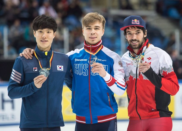 Winner Semen Elistratov of Russia, center, celebrates beside second placed Han Seungsoo of South Korea, left, and third placed Charles Hamelin of Cananda during the medal ceremony after the men's 1,500 meters final race at the World Cup short track speed skating championship in Dresden, Germany, Sunday, Feb. 8, 2015. (AP Photo/Jens Meyer)