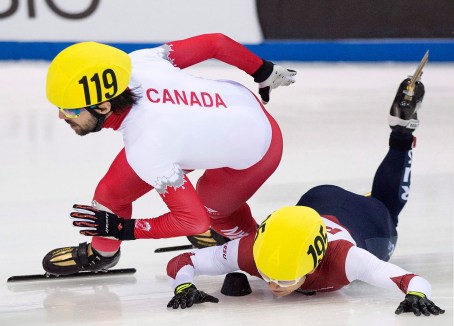 Olympic champion Victor An of Russia, right, crashes beside Olympic champion Charles Hamelin of Canada, left, during the men's 1,000 meters semi final race at the World Cup short track speed skating championship in Dresden, Germany, Saturday, Feb. 7, 2015. (AP Photo/Jens Meyer)