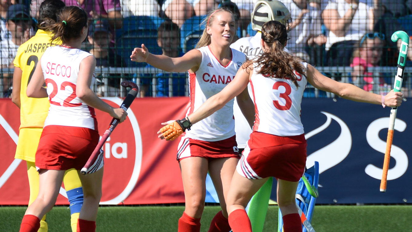 Brienne Stairs, Kate Gillis, and Maddie Secco celebrate at the 2014 Commonwealth Games in Glasgow, Scotland. Photo by: Yan Huckendubler via Field Hockey Canada. 