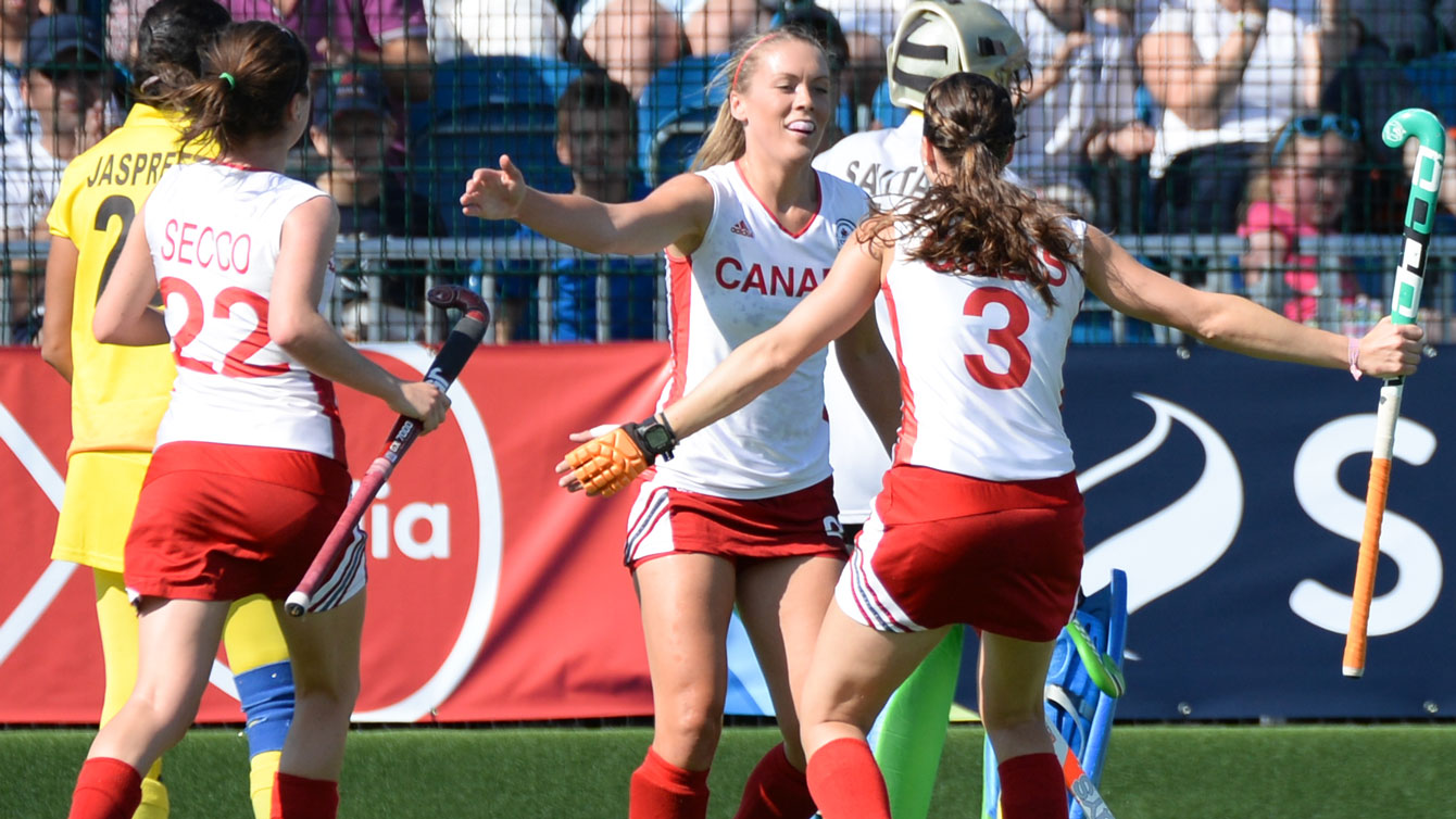 Brienne Stairs, Kate Gillis, and Maddie Secco celebrate at the 2014 Commonwealth Games in Glasgow, Scotland. Photo by: Yan Huckendubler via Field Hockey Canada.