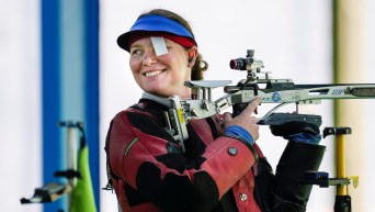 Shannon Westlake smiles while holding her rifle