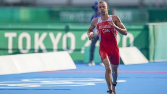 Canadian triathlete Tyler Mislawchuk runs towards his bike after the swimming portion of the triathlon during the Tokyo 2020 Olympic Games.