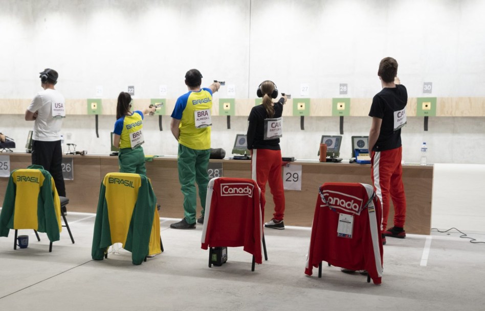 Four athletes aiming pistols at targets