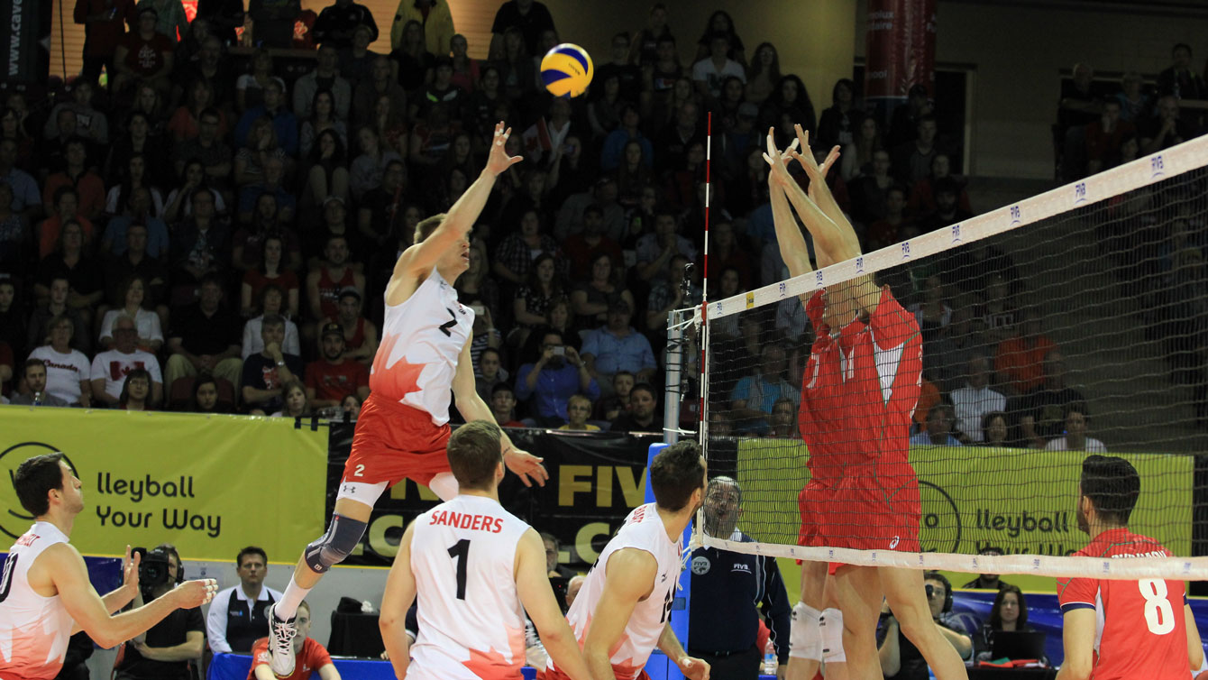 Gord Perrin tips over a Bulgarian block at FIVB World League in Summerside, PEI on June 13, 2015 (Photo: FIVB).
