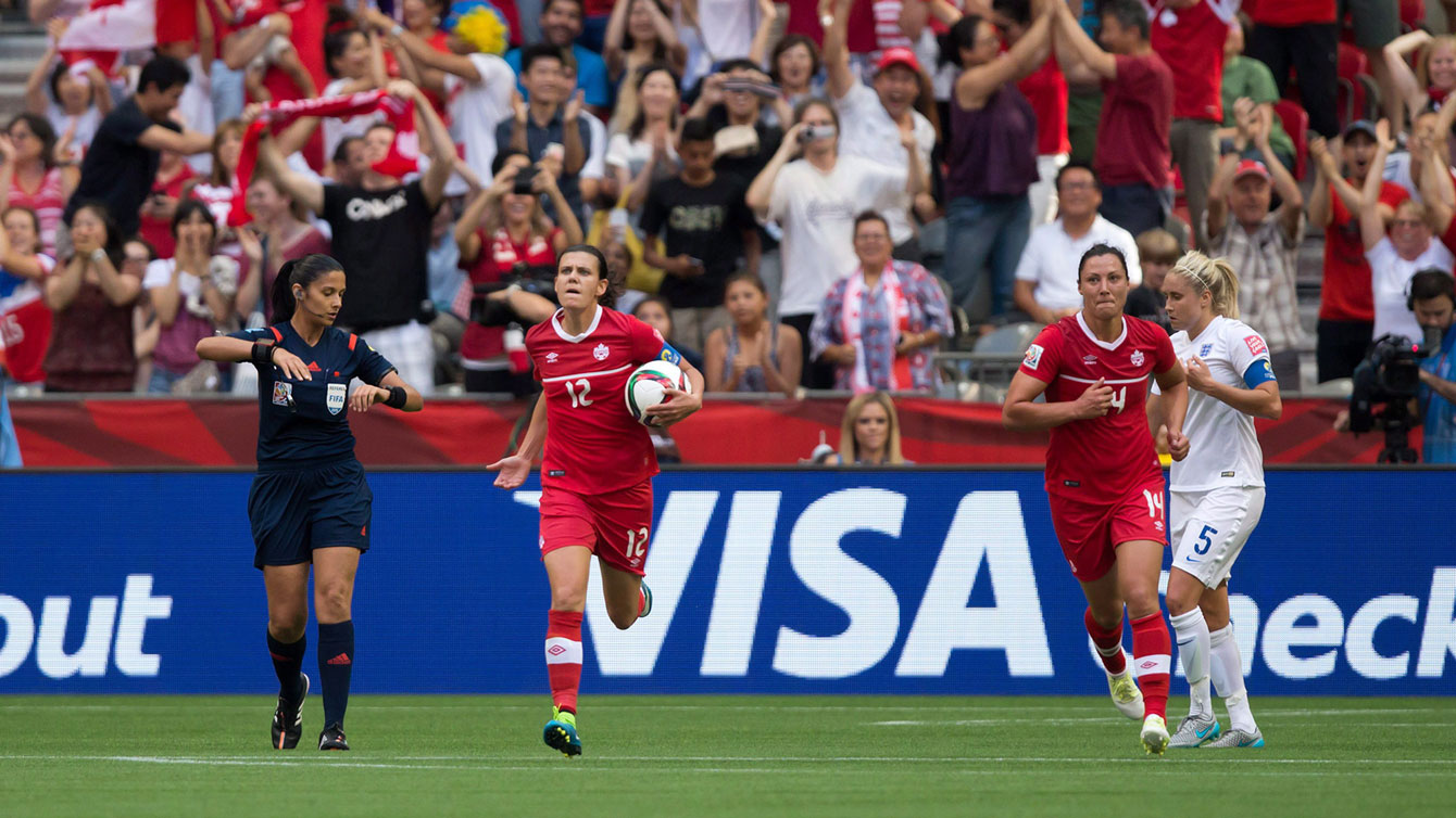 Christine Sinclair picks up the ball after scoring against England and gestures to the crowd to get behind Canada as it attempted to come back against England in a 2-1 FIFA Women's World Cup loss on June 27, 2015.