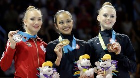 The United States' Laura Zeng, center, stands with Canada's Patricia Bezzoubenko, left, and the United States' Jasmine Kerber after winning the gold medal during rhythmic gymnastics clubs competition