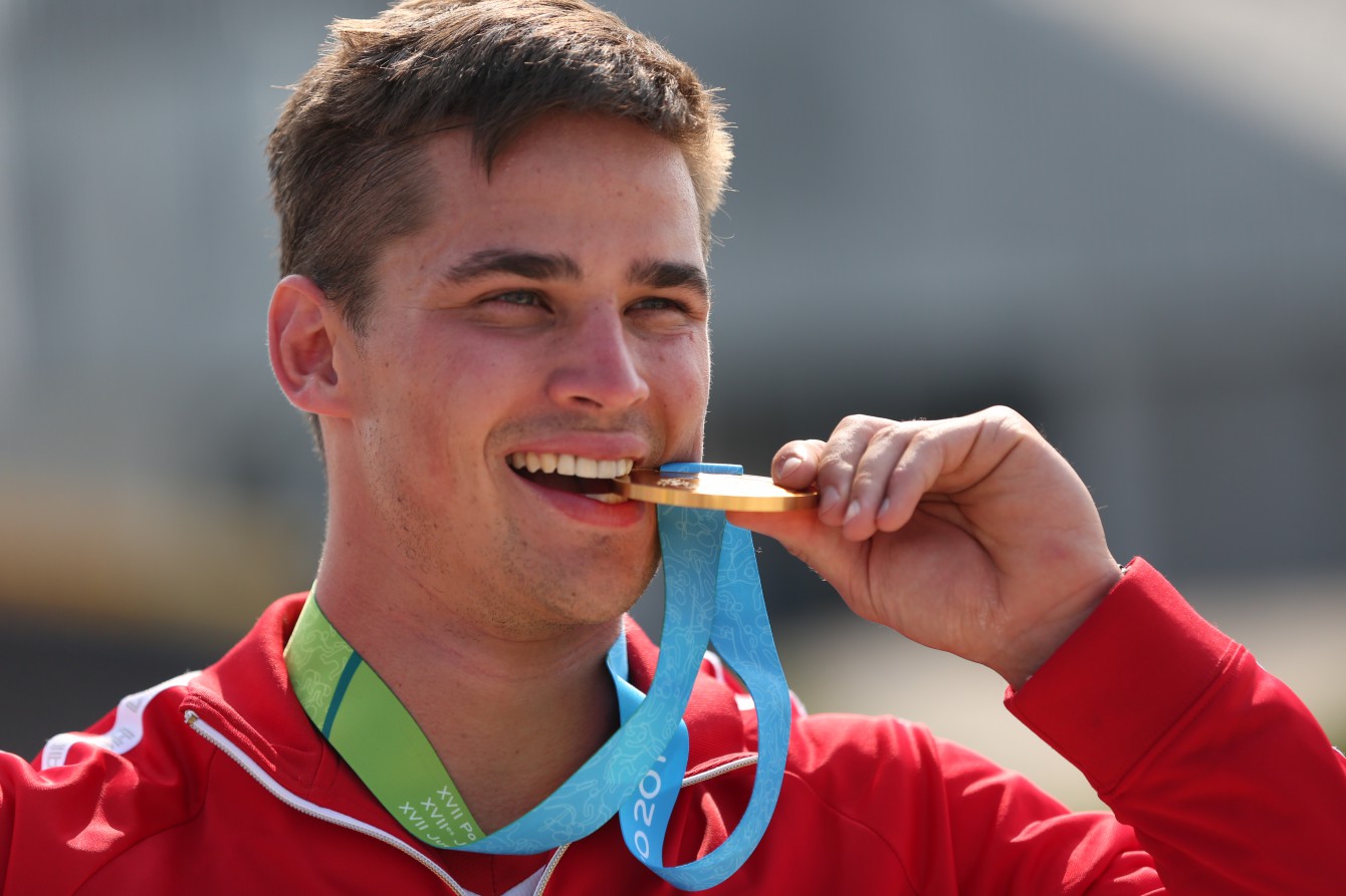 Tory Nyhaug bites his Pan Am gold medal after winning the men's BMX event on July 11, 2015. 