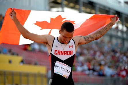 Andre De Grasse holding the Canadian flag
