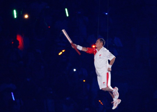 Retired Chinese gymnast Li Ning picks up a torch during Beijing 2008 Opening Ceremony.