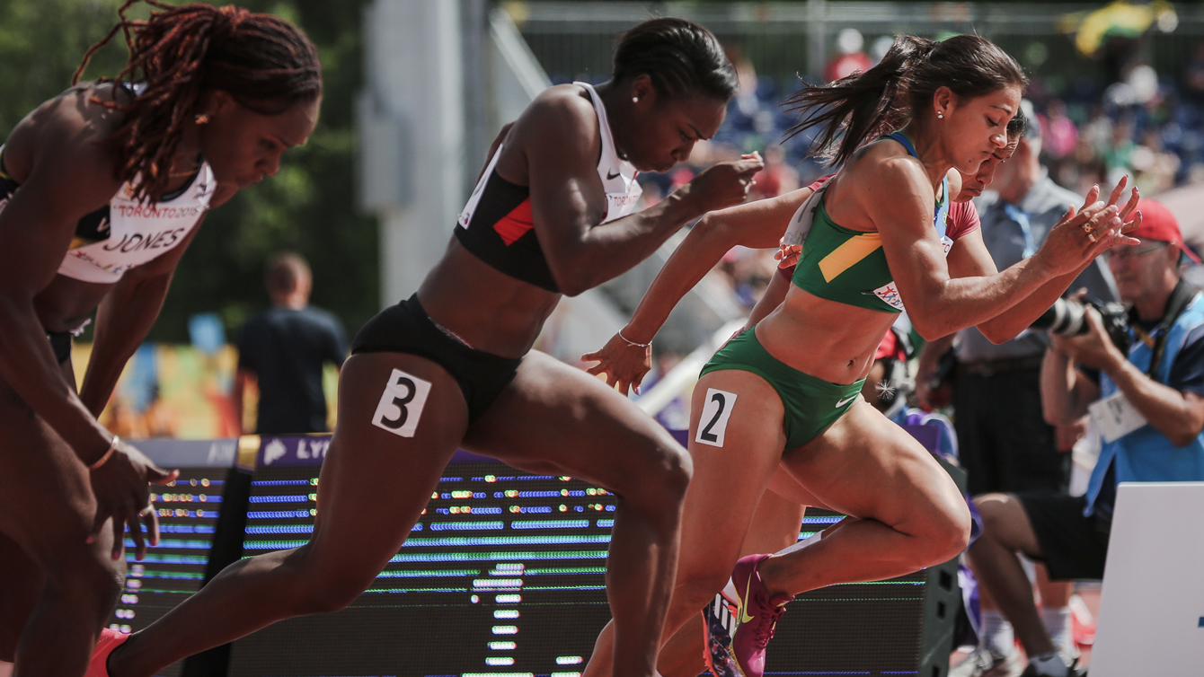 Khamica Bingham (centre) takes off at the start of the women's 100m Pan Am Games heats in Toronto on July 21, 2015.