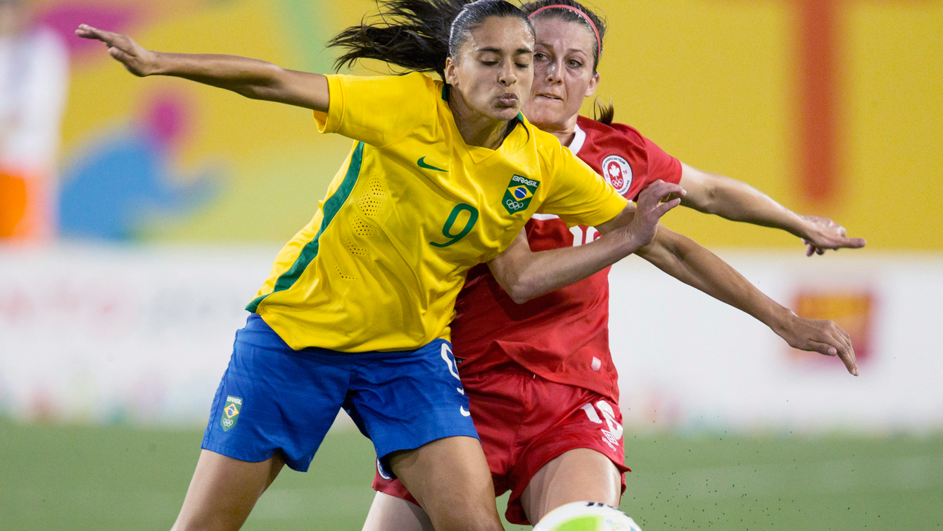 Canada's Chelsea Stewart (in red) and Brazil's Andressa Alves battle for a ball at Pan Am Games football on July 19, 2015.  