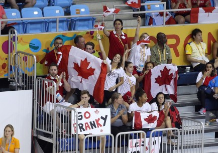 CB6P6591 Marcotte (barely visible behind a Canada flag near the right) cheers on diver François Imbeau-Dulac.