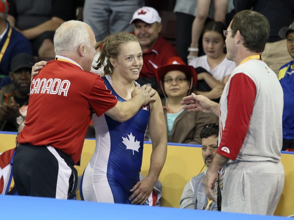 Dorothy Yeat (blue) of Montreal celebrates her gold medal with her coaches in the freestyle wrestling finals at the PanAmerican Games in Mississauga, Ont., Friday, July 17, 2015. Photo by Mike Ridewood/COC