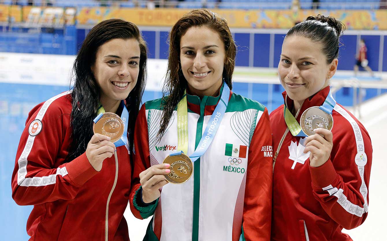 Canadians Meaghan Benfeito (left) and Roseline Filion (right) pose with 10m platform winner Paolo Espinosa of Mexico.