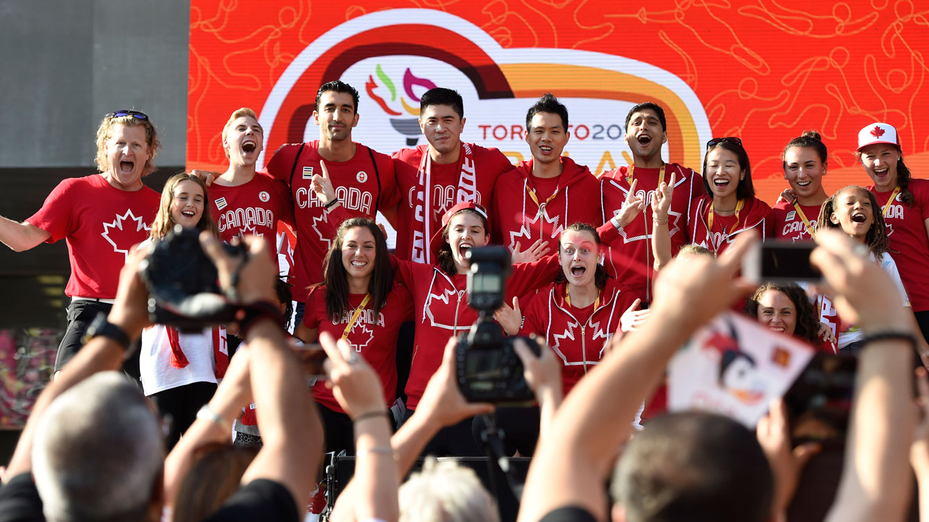 Team Canada chef de mission Curt Harnett (left, with the hair) leads athletes to the stage at Nathan Phillips Square on July 9, 2015 (Jason Ransom/COC).